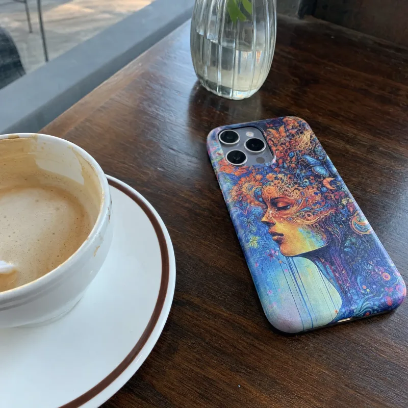 Handyhülle mit surrealem Porträt-Design auf einem Café-Tisch